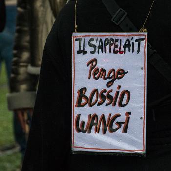 Affiche portée par un manifestant à Paris le 24 octobre 2026, en référence à la victime tuée lors de l'attentat raciste de Trappes et La Verrière (Yvelines). Il est écrit "Il s'appelait Pengo BOSSIO WANGI".